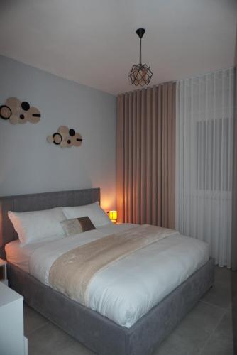 a bedroom with a large white bed in a room at DREAM Apartment in Kamëz