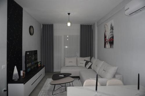 ein weißes Wohnzimmer mit einer Couch und einem Tisch in der Unterkunft DREAM Apartment in Kamëz
