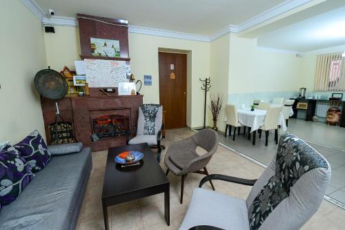 un soggiorno con divano, poltrone e camino di Arda Golden Hotel Yerevan a Yerevan