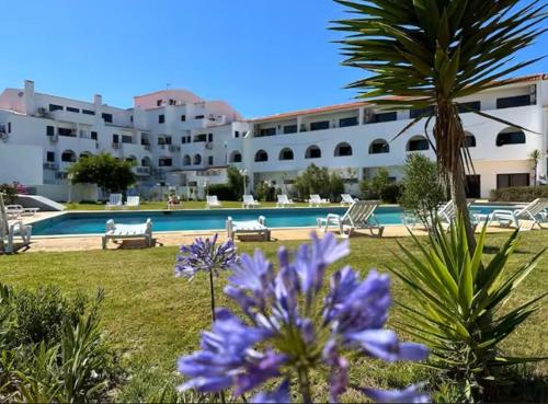 a resort with a swimming pool and purple flowers at Bella Sunset Holidays - 3 min da Praia da Mareta in Sagres