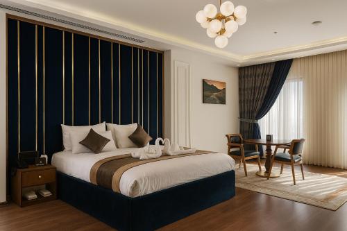 Un dormitorio con una cama grande y una mesa. en Blue Moon Hotel, en Erbil