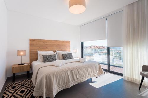een slaapkamer met een groot bed met een groot raam bij Villa view bay with Jacuzzi in Salir de Porto