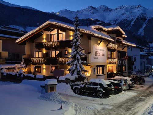 a hotel with cars parked outside of it in the snow at Frühstückspension MAIER in Sölden