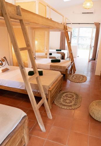 a room with three bunk beds in a room at Basecamp Yoga Beach House in Weligama