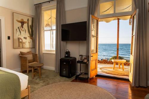 a bedroom with a room with a view of the ocean at Stoep By Ideas Cartel in Kalk Bay