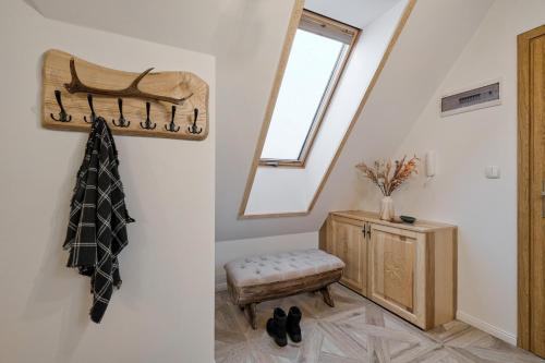 Una habitación con un espejo, un taburete y una ventana. en Apartamenty Odkryj-Bialke, en Białka Tatrzanska