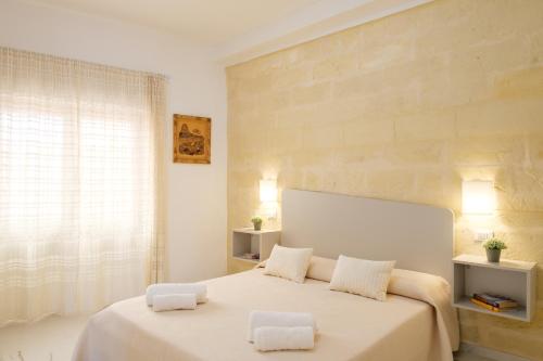 a bedroom with a large white bed with two pillows at Costa Private room in Castelsardo