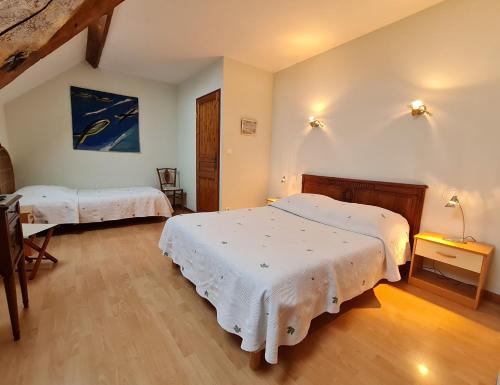 a bedroom with two beds with white sheets at "Chambre Rose", L'Ancienne Poterie in Nancray-sur-Rimarde