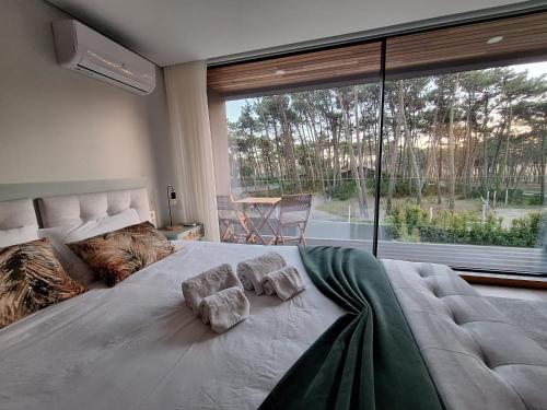 a large bed in a bedroom with a large window at Dunas D'Ofir Village in Fão