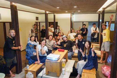 a group of people posing for a picture in a room at Bridgeブリッジゲストハウス in Shimonoseki