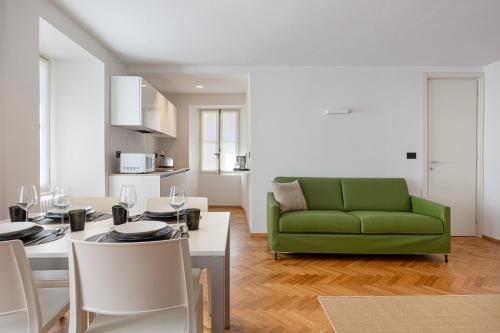 a living room with a green couch and a table at Piazza Mercato14 in Domodossola