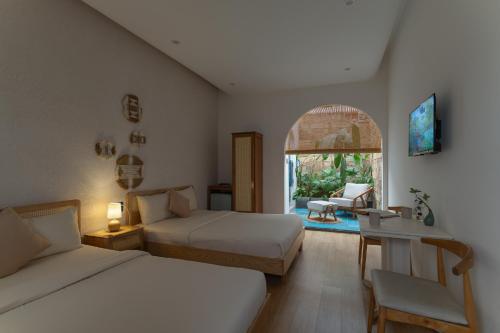 a bedroom with two beds and a living room at MOONLIGHT Homestay & Hotel in Pleiku