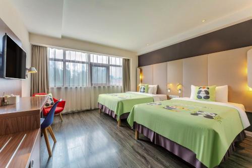 una camera d'albergo con due letti e una televisione di Campanile Xi'an Bell Tower Huimin Street a Xi'an