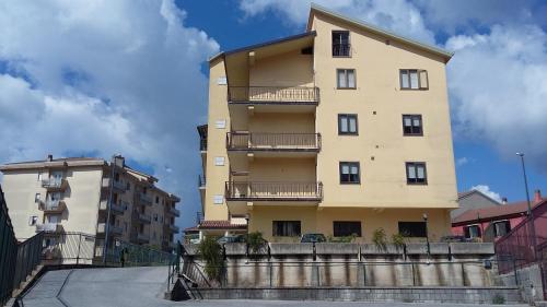 a tall yellow building with balconies on it at Hotel Caimo Bed-Breakfast in Lagonegro