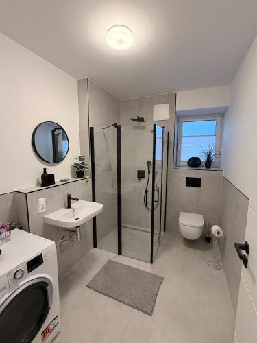 a bathroom with a shower and a toilet and a sink at Maritime Suite an der Geeste in Bremerhaven