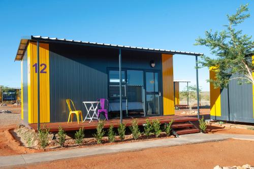 a yellow and black house with a table and chairs at SleepOver Colesberg in Colesberg