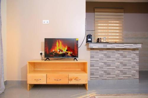 a flat screen tv sitting on top of a wooden entertainment center at Betimu Residence in Kisoro