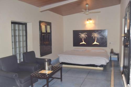 Casa Aranya - A Heritage Retreat في مونت ابو: غرفة نوم بها سرير وأريكة وطاولة