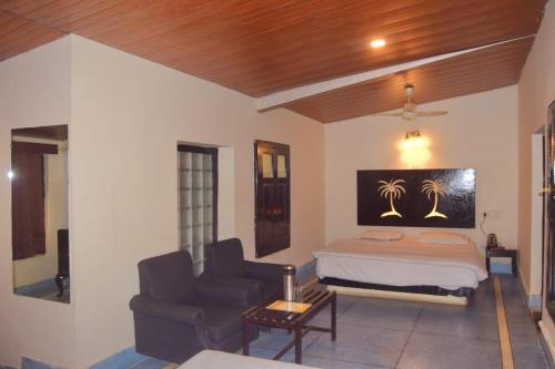Casa Aranya - A Heritage Retreat في مونت ابو: غرفة نوم بها سرير وأريكة وكرسي