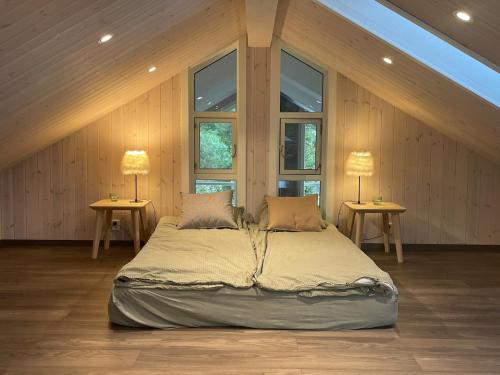 Un dormitorio con una cama grande con dos lámparas sobre dos mesas. en Cabin on hardangerfjord, 