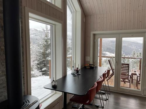 Una habitación con una mesa y sillas y una ventana grande. en Cabin on hardangerfjord, 