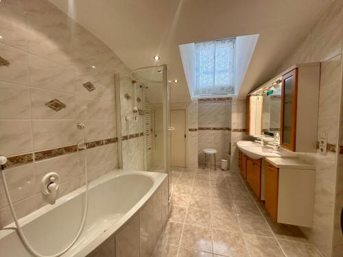 a bathroom with a tub and two sinks and a shower at Ferienwohnungen Roderer in Berchtesgaden