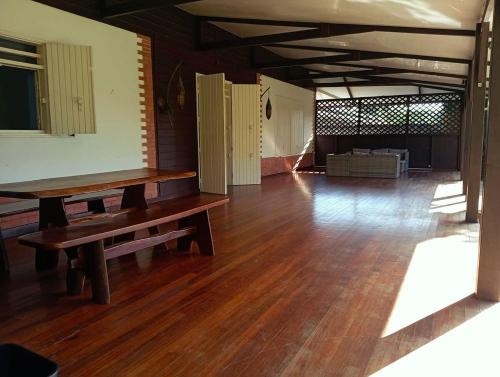 a large room with a wooden floor and a bench at La Villa des Palmiers Bleus - Piscine & Jardin in La Valère