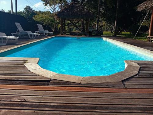 a swimming pool with blue water and some chairs at La Villa des Palmiers Bleus - Piscine & Jardin in La Valère