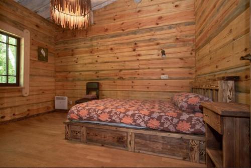 - une chambre avec un lit dans une cabane en rondins dans l'établissement Namelis šalia vynuogyno, à Būdziliai