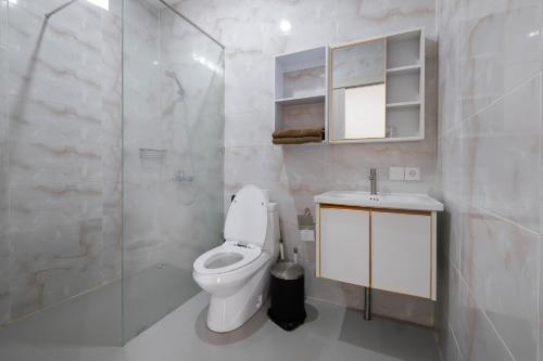 a bathroom with a toilet and a sink and a shower at Puri Kasih Home Stay in Sanur