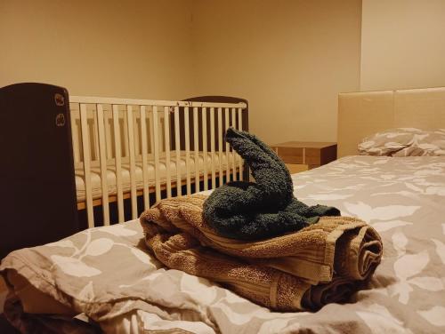 a baby crib sitting on a blanket on a bed at Apartament z Jacuzzi in Częstochowa