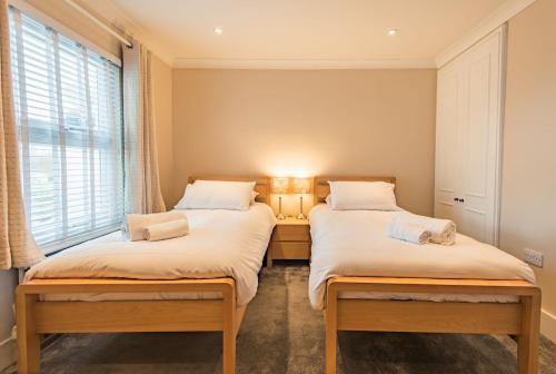 two twin beds in a room with a window at Middle Cottage by Keepers Cottages in Sandwich