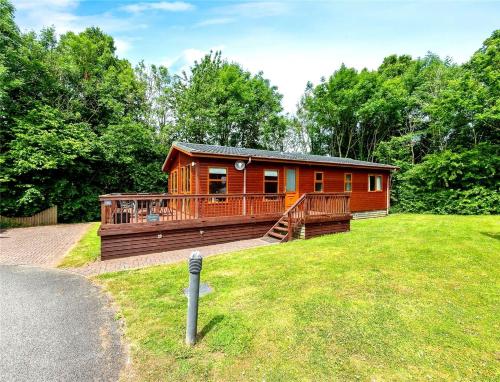a large wooden cabin with a large deck at Mariners Lodge in Saint Minver