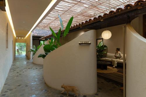 a hallway with plants and a woman sitting on a couch at MOONLIGHT Homestay & Hotel in Pleiku