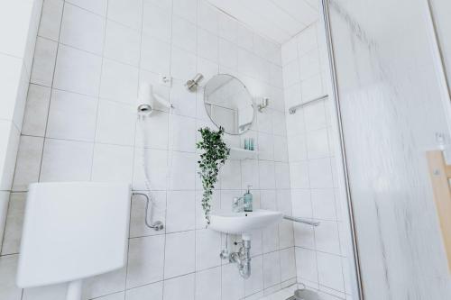 Un baño blanco con lavabo y espejo. en Gemütliche Ferienwohnung im historischen Gästehaus, en Boppard