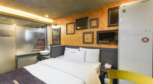 a bedroom with a white bed and a bathroom at Jukdo market G1mini in Pohang