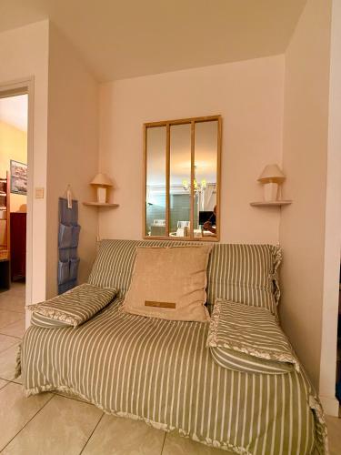 a bed with two pillows in a room at Charmant T2 à 100m de la plage in Bénodet