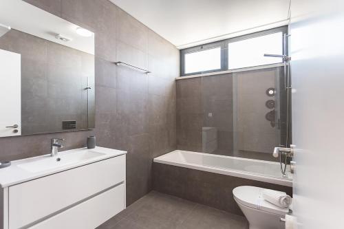 een badkamer met een bad, een toilet en een wastafel bij Villa view bay with Jacuzzi in Salir de Porto