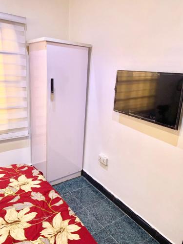 a bedroom with a bed and a flat screen tv at Adel’s Place in Abuja
