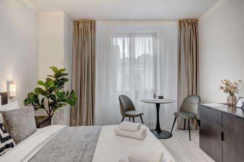 En eller flere senge i et værelse på L'Heritage Collection Romana Apartments