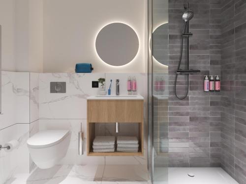 een badkamer met een douche, een toilet en een wastafel bij Numa Rotterdam Coolsingel in Rotterdam