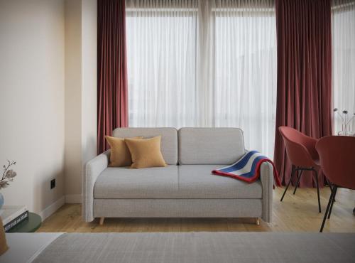 een woonkamer met een bank voor een raam bij Numa Rotterdam Coolsingel in Rotterdam