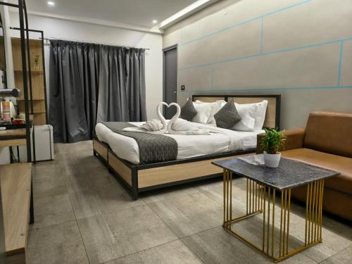 a bedroom with a bed and a table and a couch at RESTEL STUDIO FLATS in Hyderabad