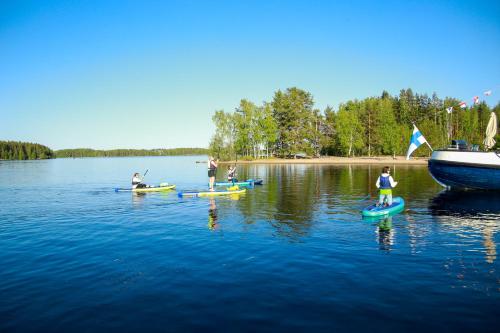a group of people on paddle boards in the water at Saimaa Experience in Savonlinna