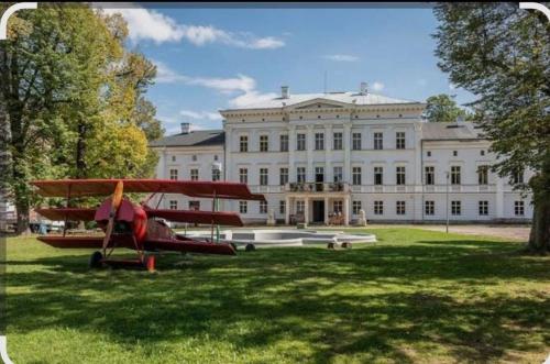 a red plane parked in front of a large building at Apartament w Starej Szkole in Zagórze Śląskie