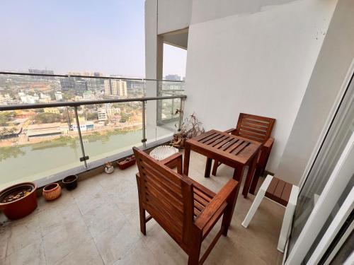 Un balcón con dos bancos y una mesa en un edificio. en Aesthetic Modern 2BHK Work & Relax Balcony Views, en Jāmb