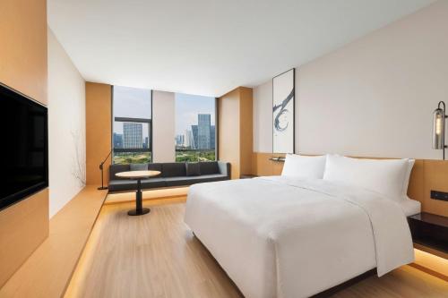 a hotel room with a bed and a television at Fairfield by Marriott Hangzhou Future Sci-tech City in Hangzhou