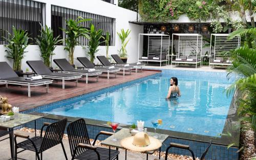 a woman in the swimming pool at a hotel at The Calm Oasis in Siem Reap