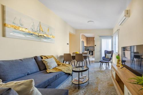 a living room with a blue couch and a table at 74 Prokymea- Steps from the Sea, Downtown, Balcony in Limassol