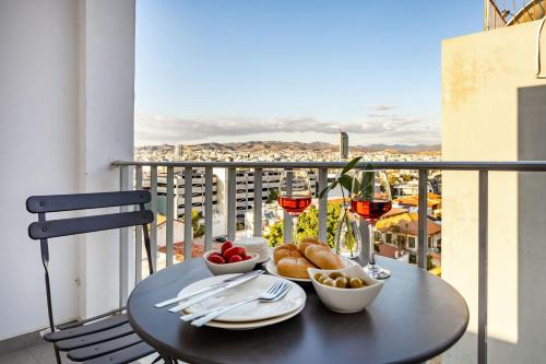 a table with food and glasses of wine on a balcony at 74 Prokymea- Steps from the Sea, Downtown, Balcony in Limassol